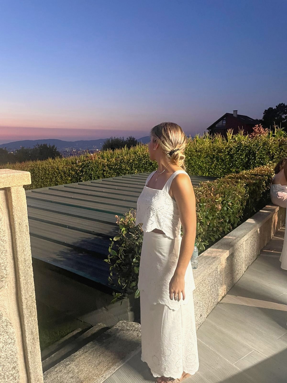 Clienta con vestido blanco y ramo al atardecer