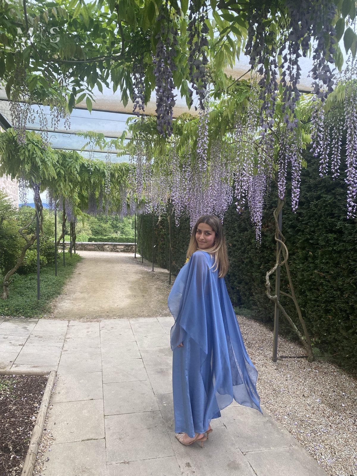 Vestido con capa azul de gasa, bajo las glicinias